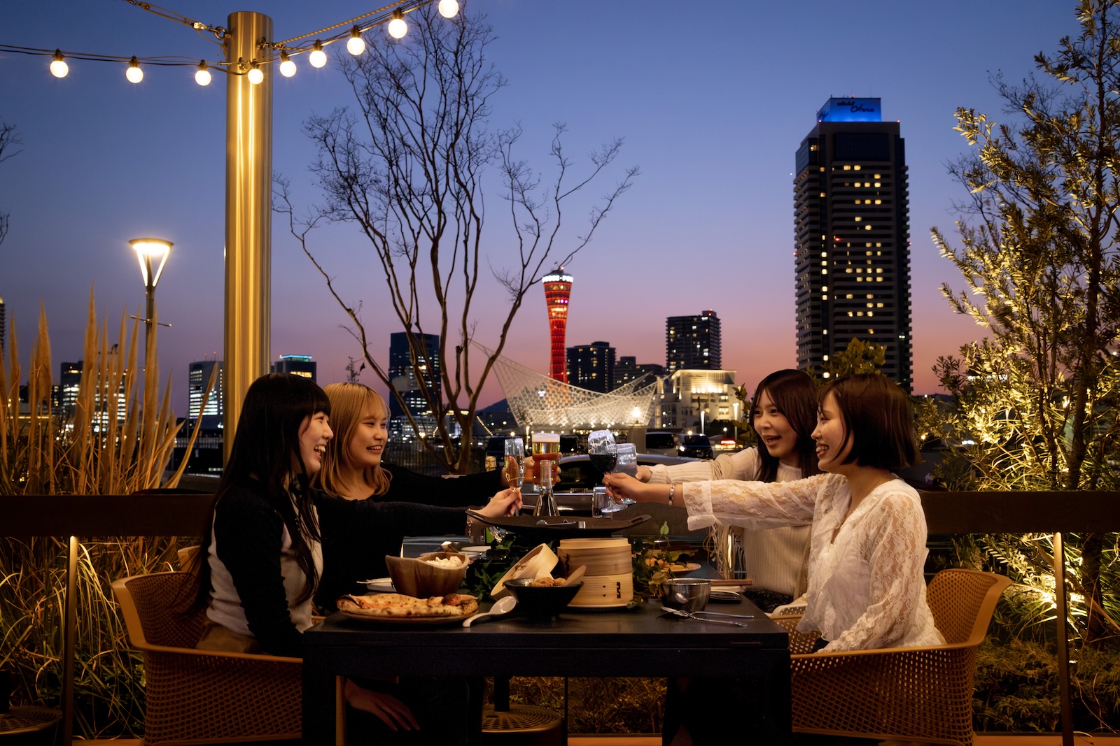 神戸の夜景を背景に乾杯する画像